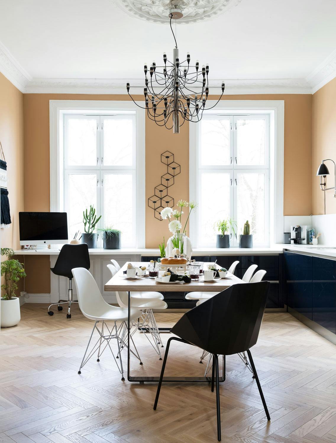 Fiskebein på gulv og bord Stort kjøkken med svart innredning og beige vegger